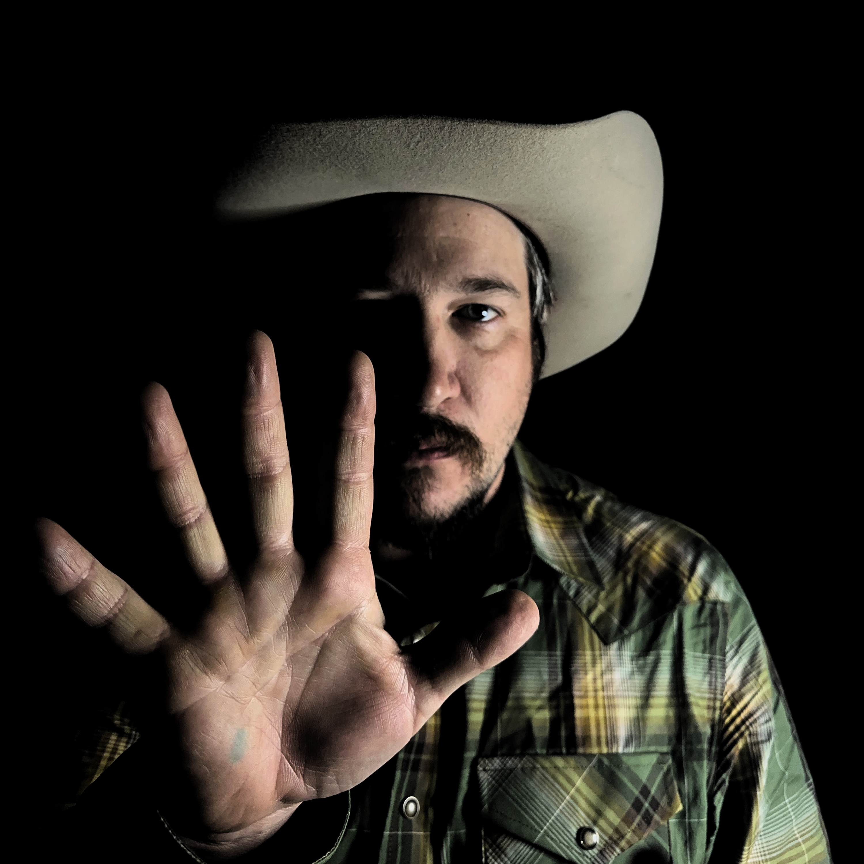 Dusty Rust portrait with raised hand and black background
