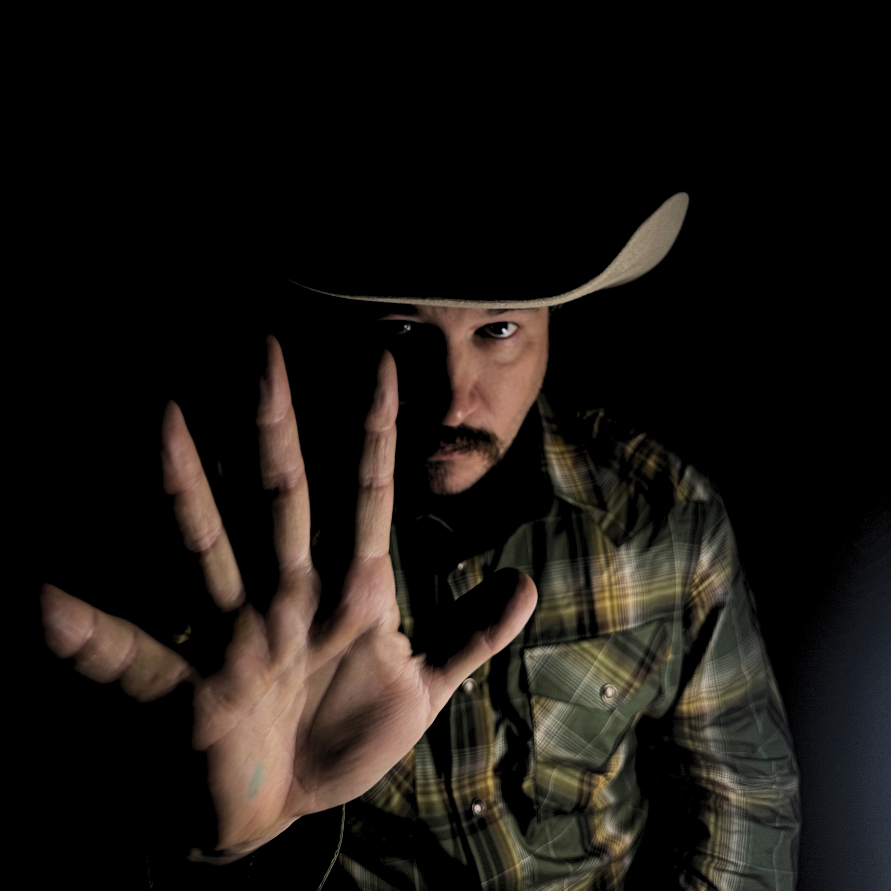 Dusty Rust portrait with outstretched hand and black background
